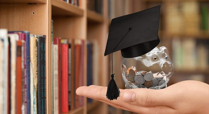 A piggybank wearing a graduate cap.